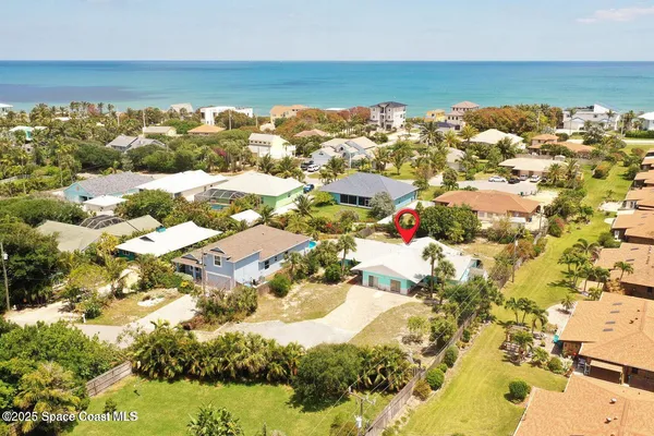 an aerial view of a city with lots of residential buildings and ocean view in back
