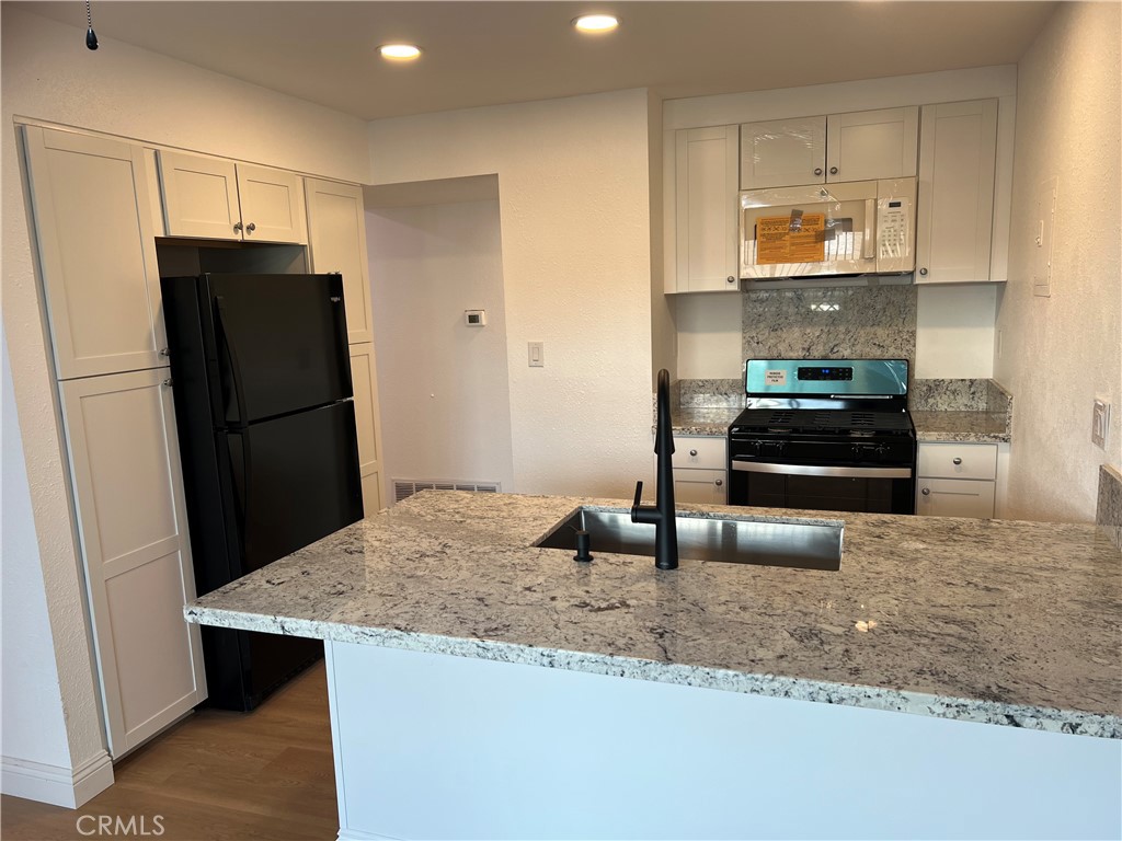 2255 Cahuiila Street, Unit 73 Colton, CA 92324 - Photo 2 of 12 a kitchen with granite countertop a refrigerator and a sink
