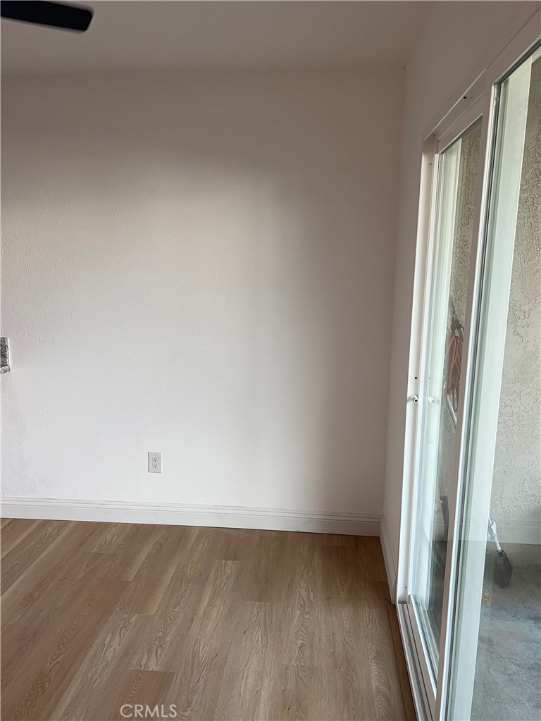 2255 Cahuiila Street, Unit 73 Colton, CA 92324 - Photo 6 of 12 an empty room with wooden floor and door