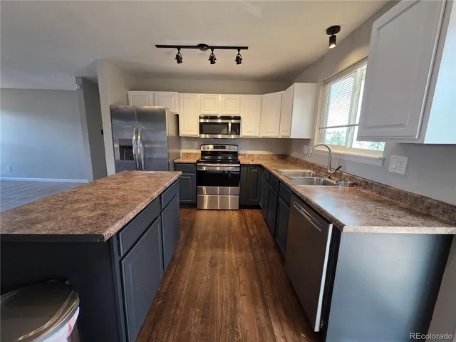 a kitchen with stainless steel appliances kitchen island granite countertop a stove a sink and a microwave