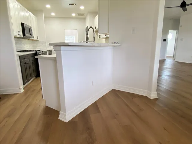 a view of a kitchen with a sink wooden floor and a window