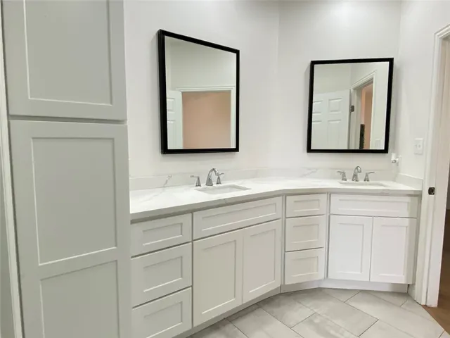 a bathroom with a double vanity sink and mirror