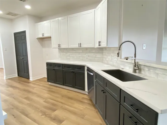 a kitchen with a sink and a stove top oven