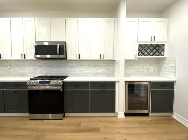 a kitchen with stainless steel appliances granite countertop a stove and a microwave