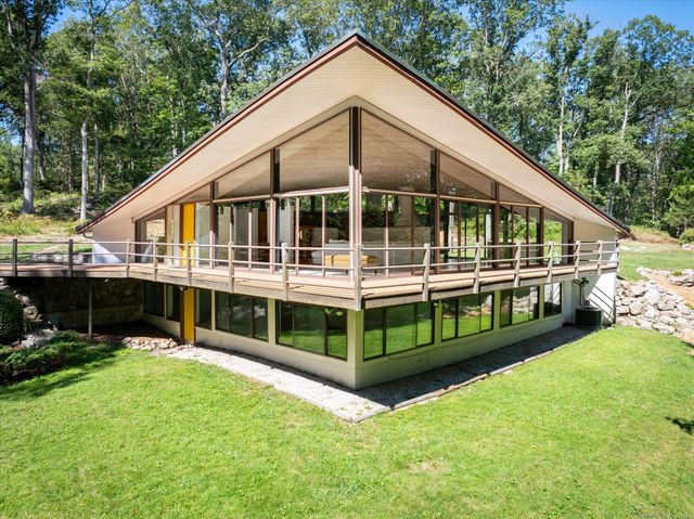 a view of a patio with table and chairs with wooden floor and fence