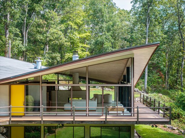 a view of a patio with table and chairs potted plants and large tree
