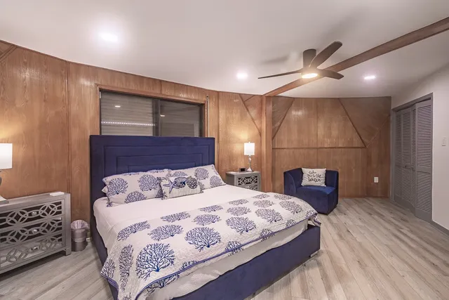 a bedroom with a large bed and a chandelier