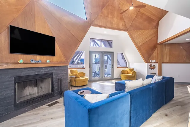 a living room with furniture a flat screen tv and a fireplace