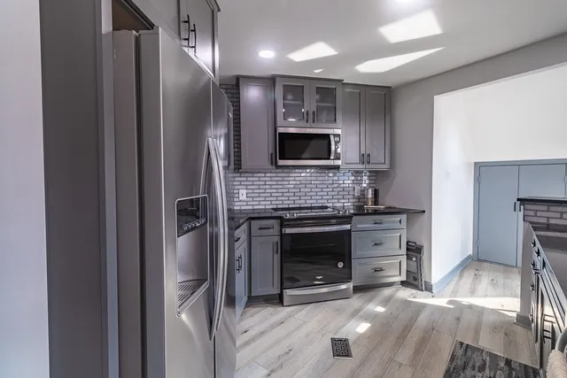 a kitchen with stainless steel appliances granite countertop a refrigerator and a stove top oven