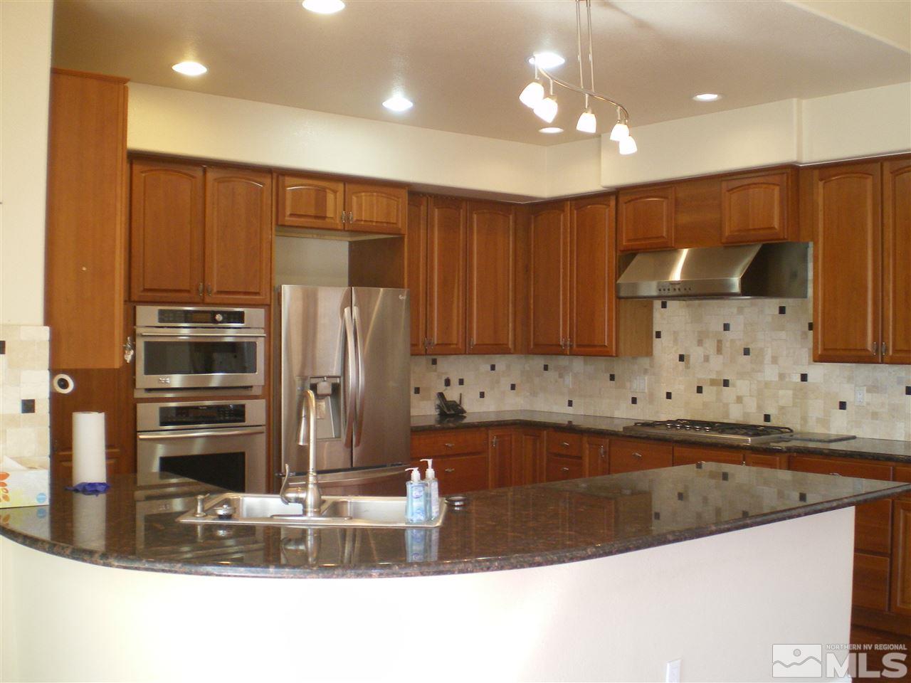 370 Flanders Road Reno, NV 89511 - Photo 18 of 25 a kitchen with kitchen island granite countertop a sink and cabinets