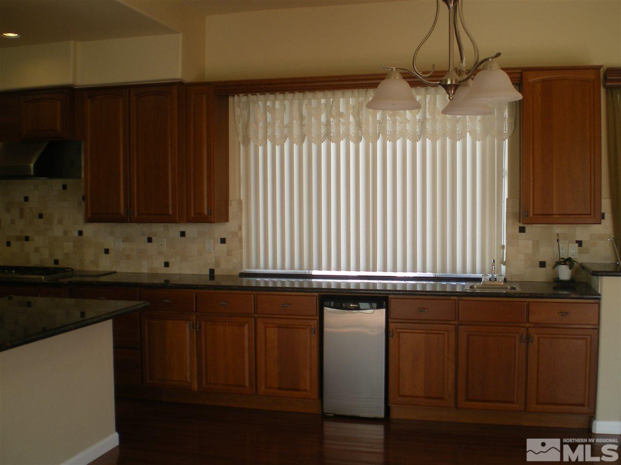 370 Flanders Road Reno, NV 89511 - Photo 19 of 25 a kitchen with granite countertop wooden cabinets and a black umbrella