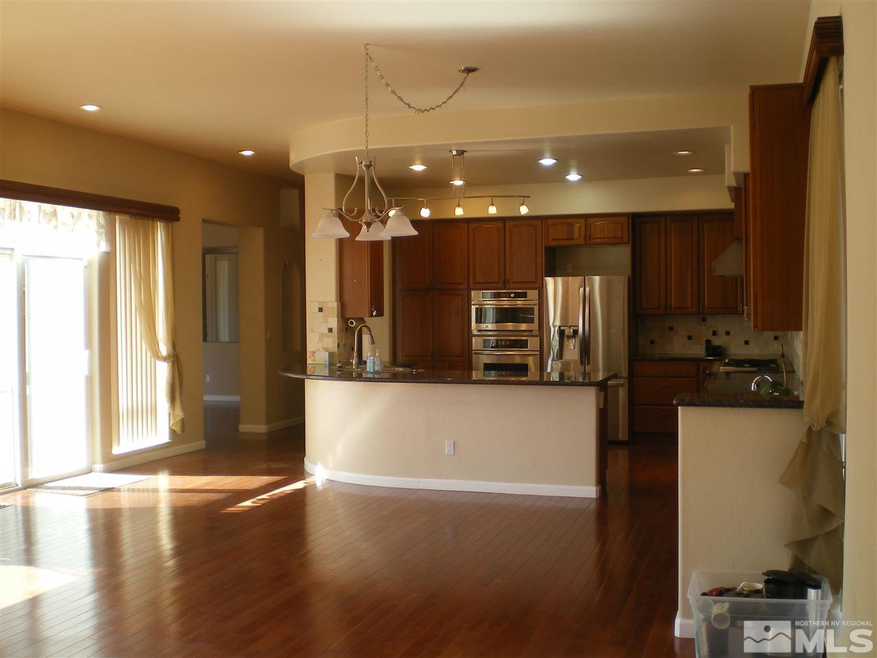 370 Flanders Road Reno, NV 89511 - Photo 21 of 25 a view of a kitchen with stainless steel appliances a large counter top and a wooden floors