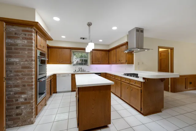 a kitchen with stainless steel appliances granite countertop a stove a sink and a refrigerator