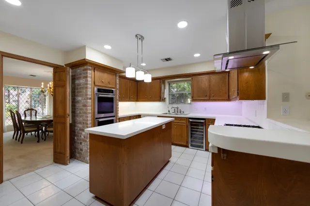 a kitchen with kitchen island a sink stainless steel appliances and cabinets
