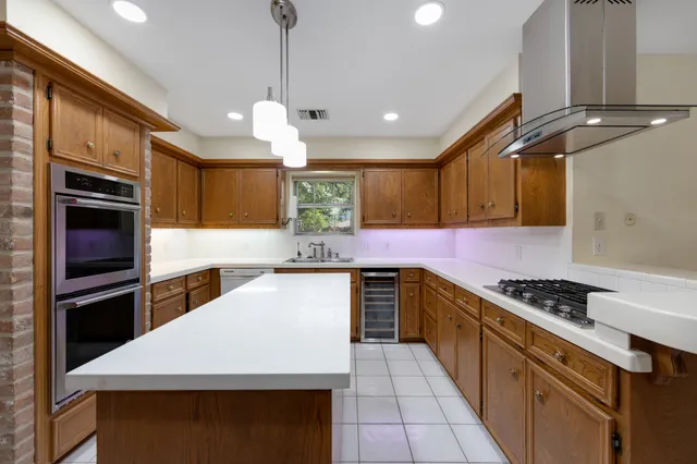 a kitchen with stainless steel appliances a sink a stove cabinets and a counter top space