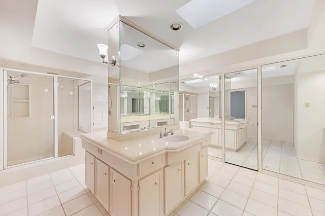 a spacious bathroom with a shower sink and mirror
