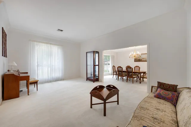 a living room with furniture and two large window