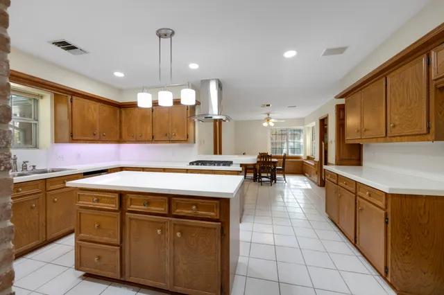a kitchen with a stove a sink cabinets and a kitchen island