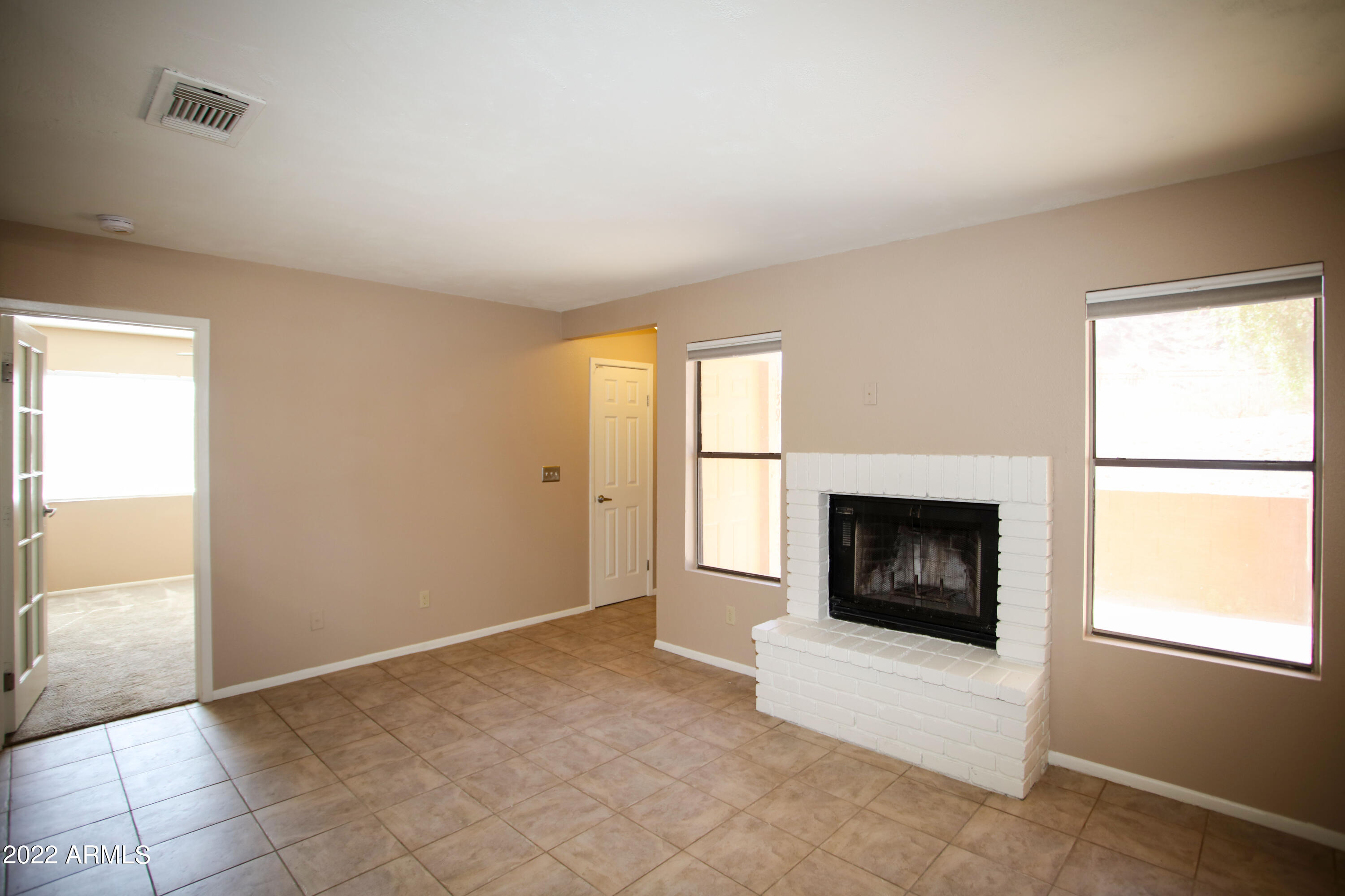 3511 East Baseline Road, Unit 1159 Phoenix, AZ 85042 - Photo 14 of 33 an empty room with fireplace and windows