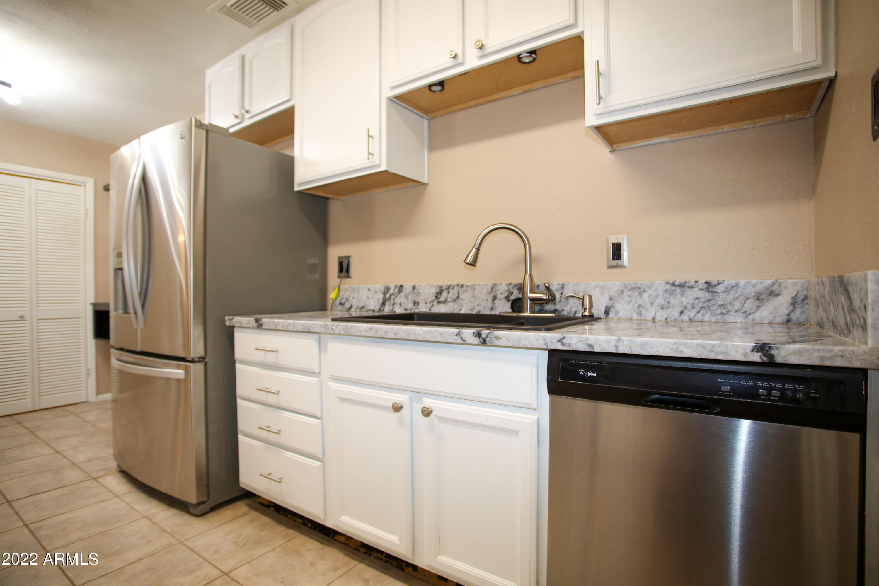 3511 East Baseline Road, Unit 1159 Phoenix, AZ 85042 - Photo 9 of 33 a kitchen with granite countertop a refrigerator and a sink
