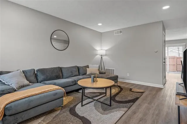 a living room with furniture a rug a lamp and a rug