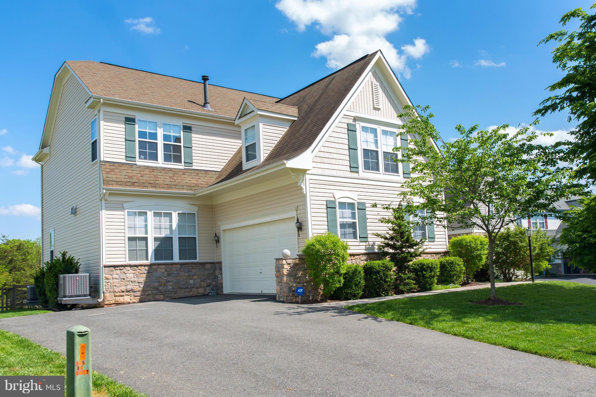 12403 Rochester Park Court Bristow, VA 20136 - Photo 2 of 30 a front view of a house with a yard and trees