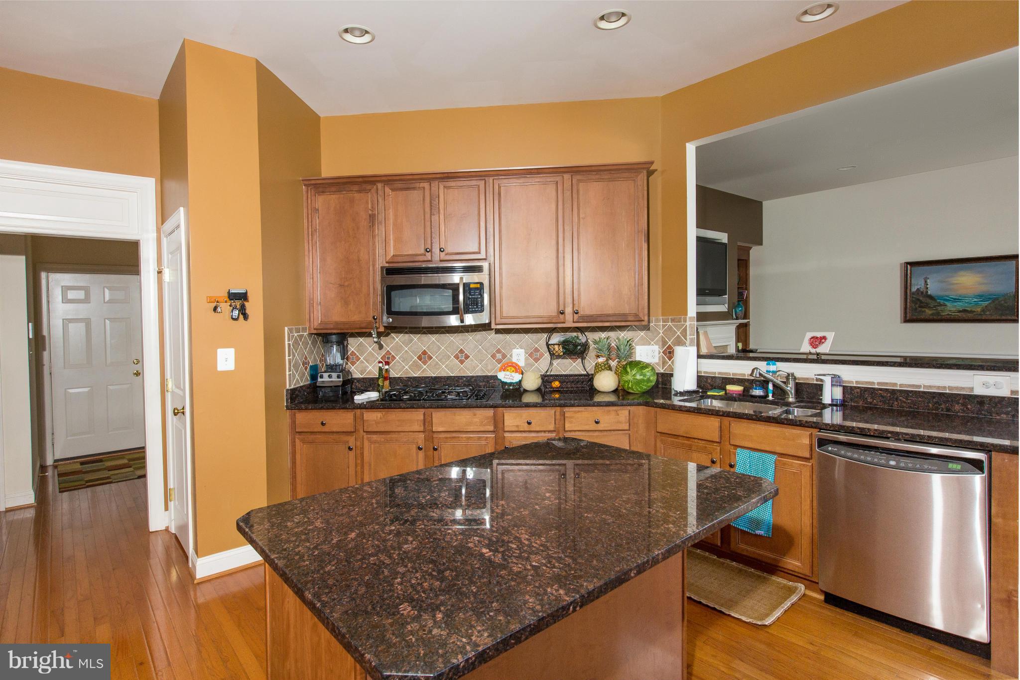 12403 Rochester Park Court Bristow, VA 20136 - Photo 12 of 30 a kitchen with stainless steel appliances granite countertop a sink a stove and a refrigerator
