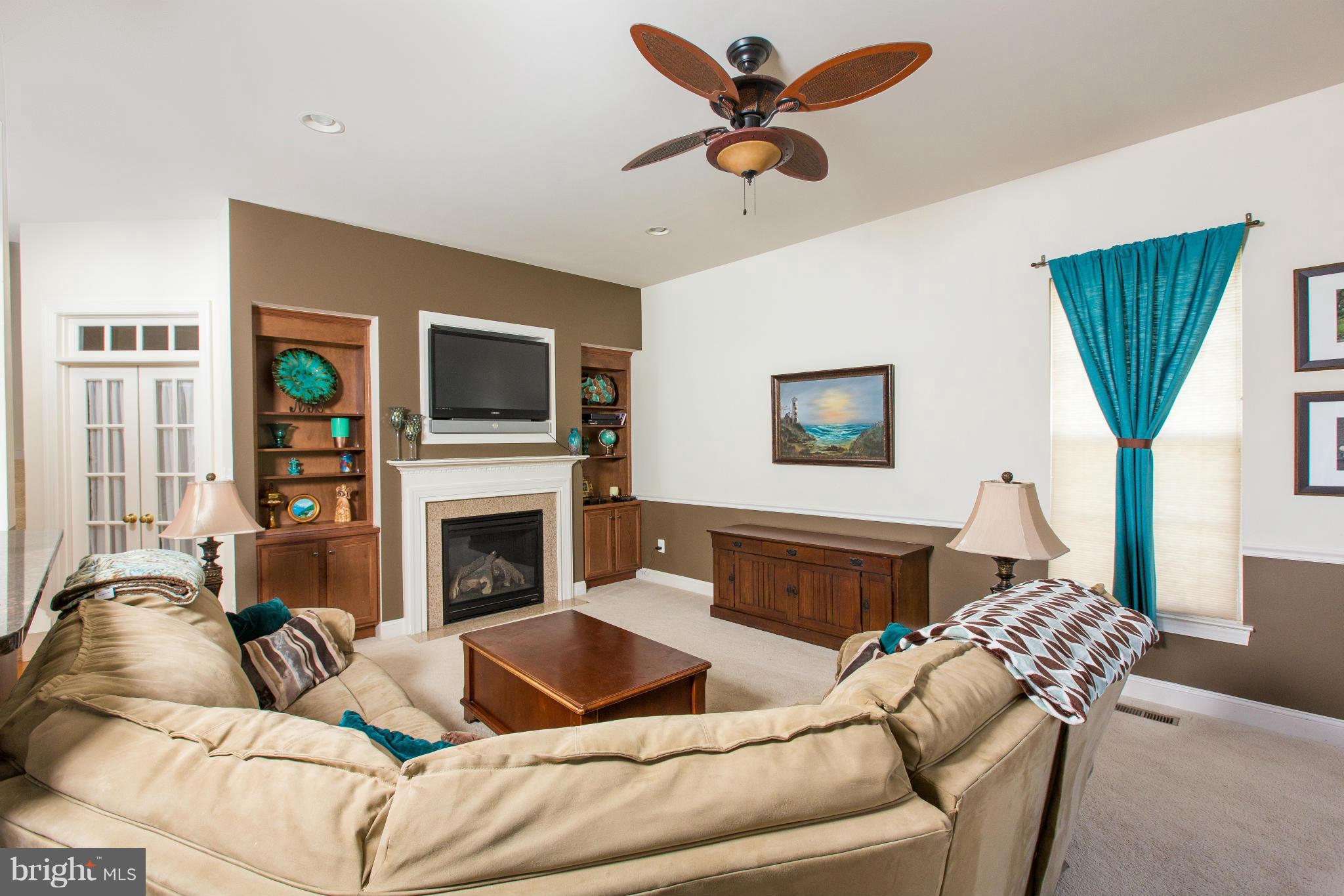 12403 Rochester Park Court Bristow, VA 20136 - Photo 16 of 30 a living room with furniture ceiling fan and a fireplace