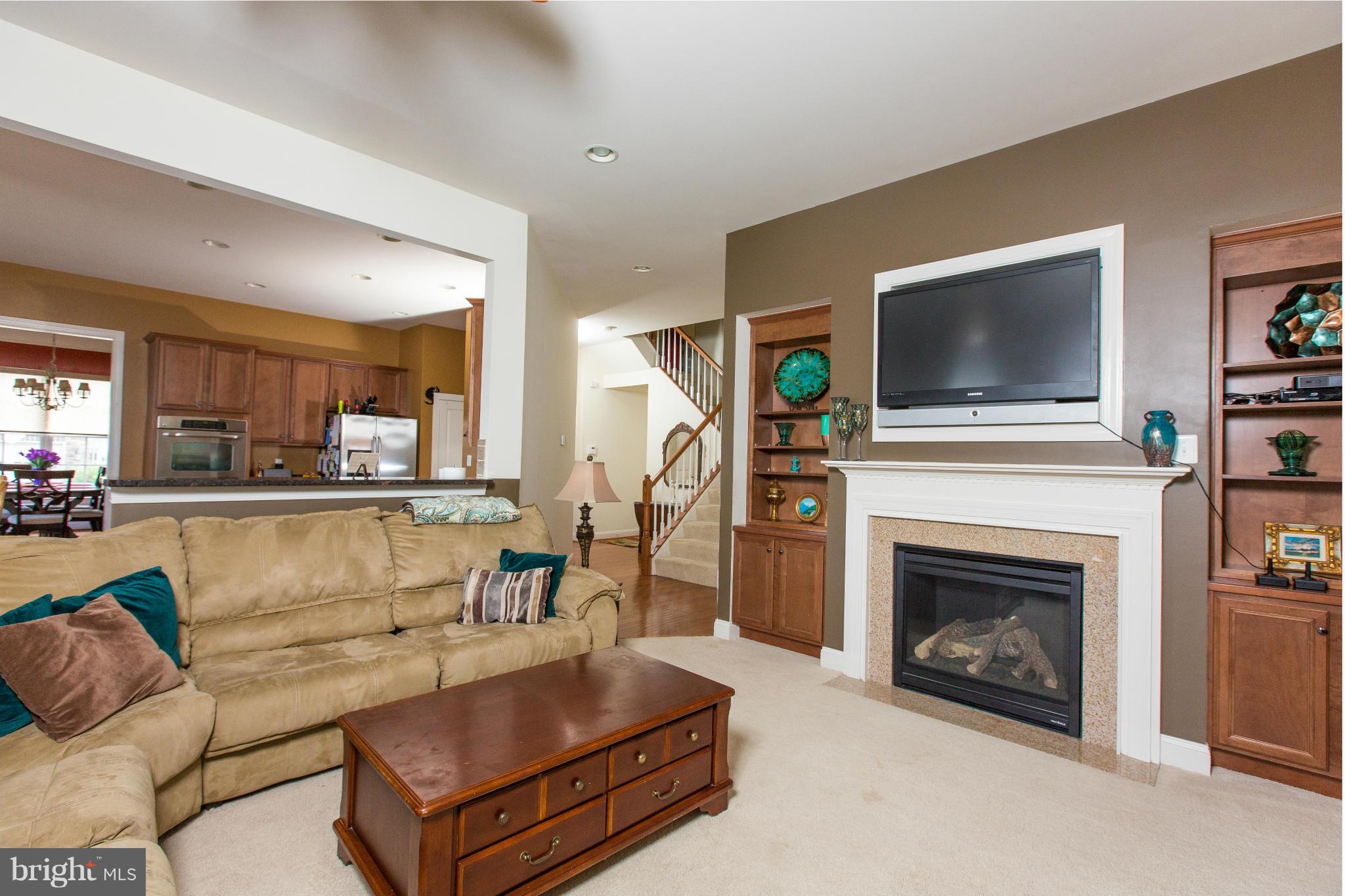 12403 Rochester Park Court Bristow, VA 20136 - Photo 17 of 30 a living room with furniture a flat screen tv and a fireplace