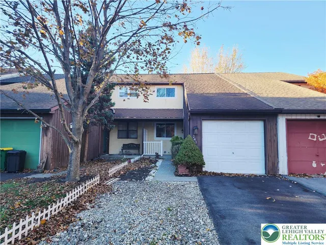 a view of a house with a tree and front view