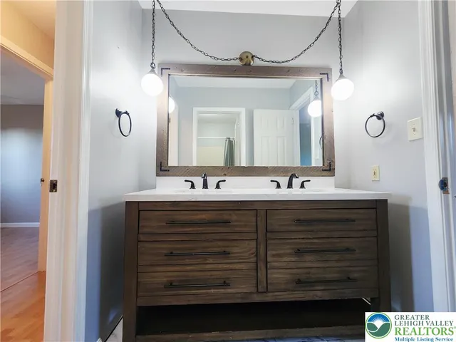 a bathroom with a double vanity sink and a mirror