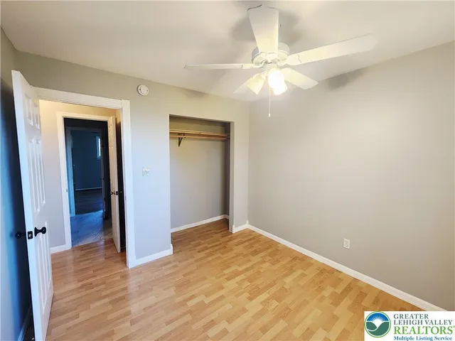 an empty room with a window and a fan