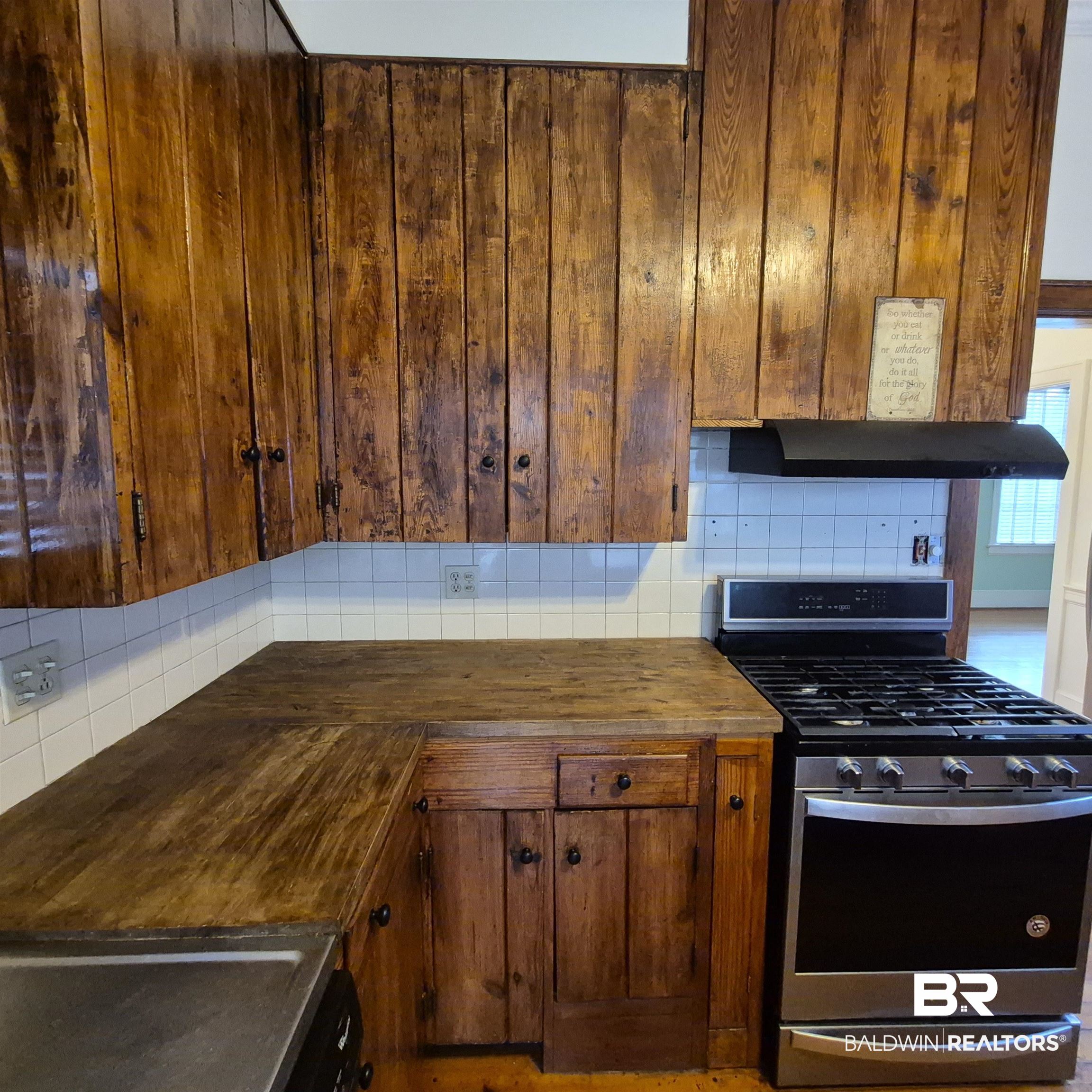 308 Rural Street Evergreen, AL 36401 - Photo 19 of 40 Kitchen featuring stainless steel gas stove, wood counters, backsplash, and extractor fan