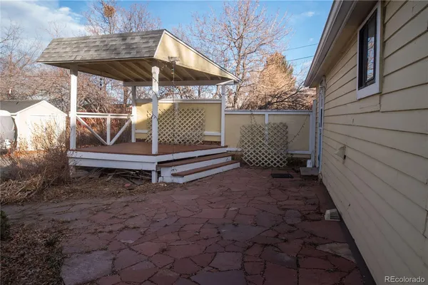 a side view of a house with a yard and wooden fence