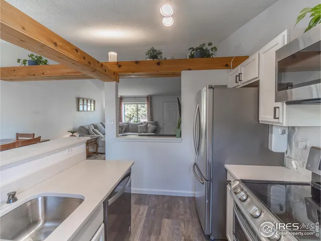 a kitchen that has a sink a refrigerator and a stove top oven