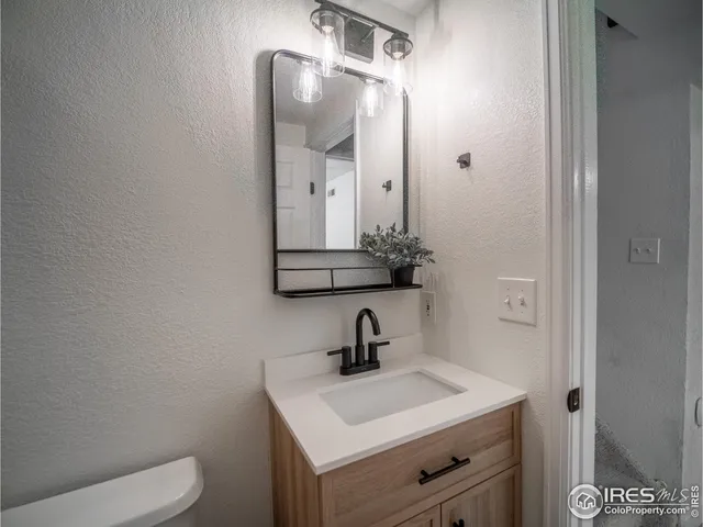 a bathroom with a sink a toilet and a mirror
