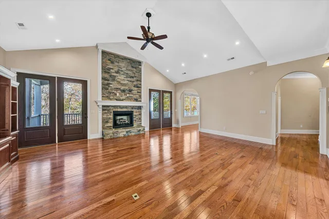 a view of empty room with kitchen and fireplace