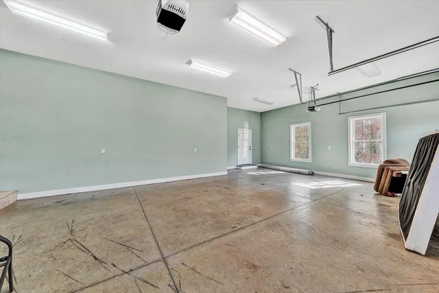 a view of a hallway with wooden floor and a bathroom
