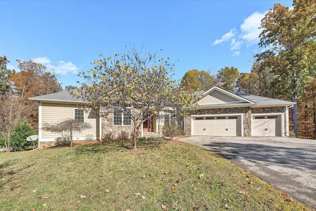 a view of an empty room with wooden floor and a fireplace