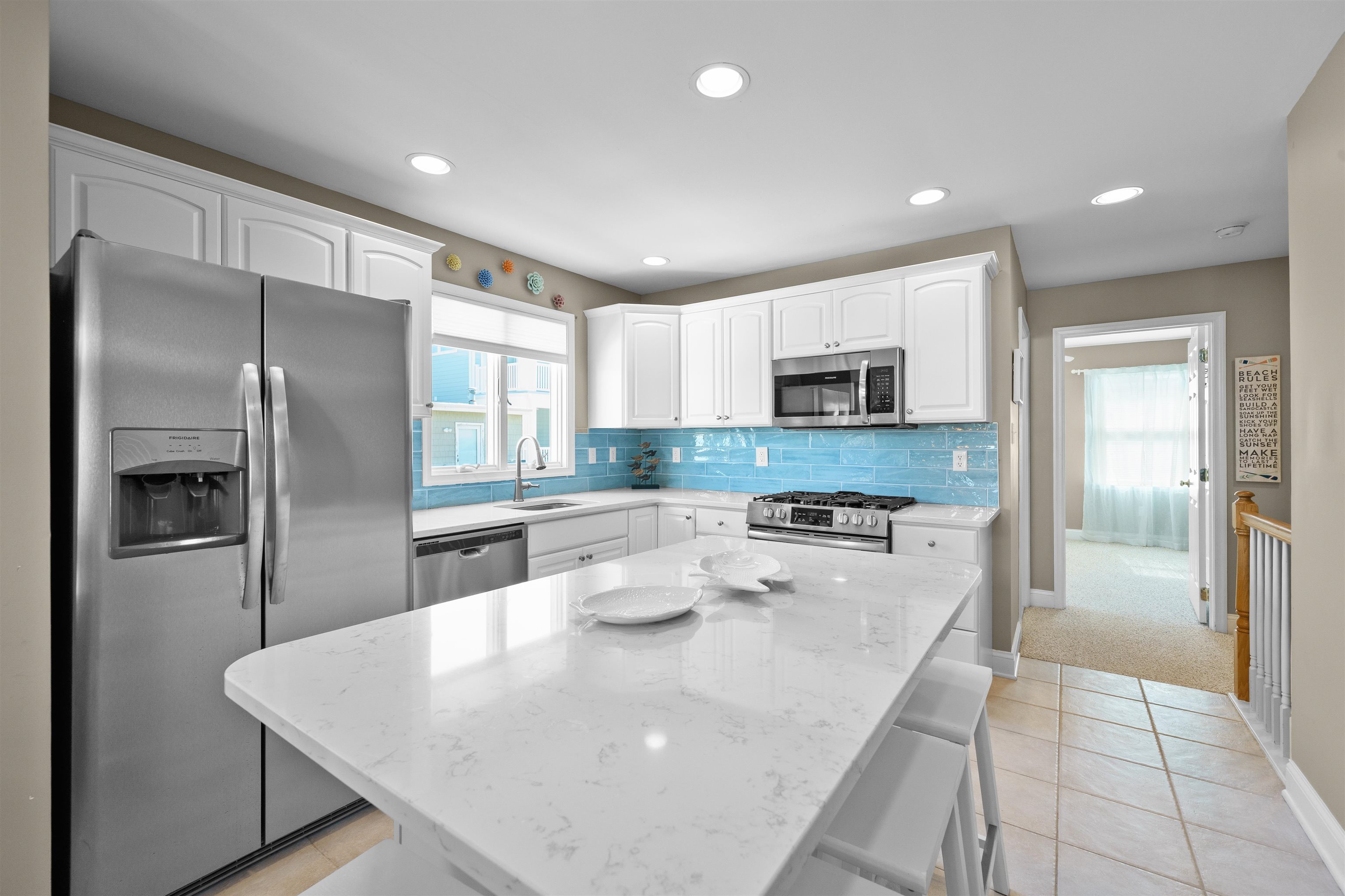 212 25th Street, Unit END Avalon, NJ 08202 - Photo 6 of 34 a kitchen with stainless steel appliances granite countertop a refrigerator a stove and a sink with wooden floor