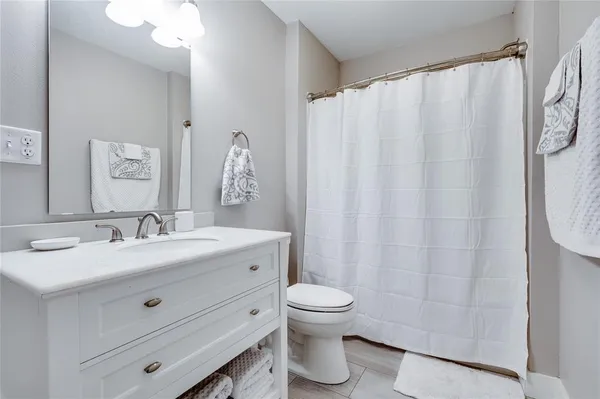 a spacious bedroom with a bed and a chandelier