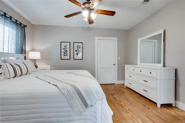 a bedroom with a bed and a chandelier fan