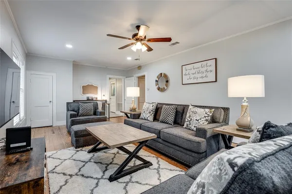 a living room with furniture and wooden floor
