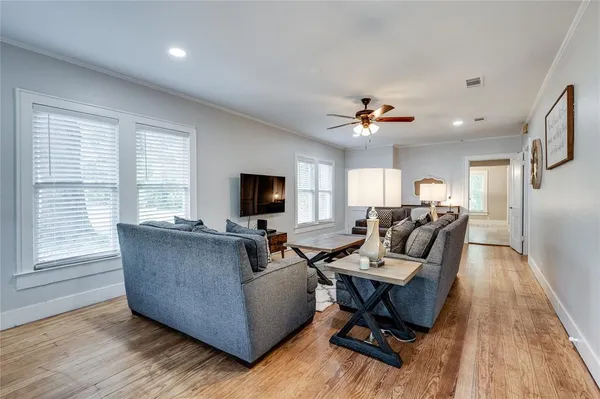 a living room with furniture ceiling fan and a window