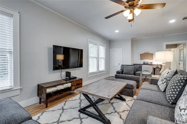 a living room with furniture and a wooden floor