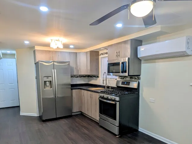a kitchen with stainless steel appliances granite countertop a stove a refrigerator and a microwave