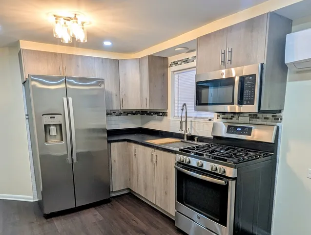 a kitchen with stainless steel appliances a refrigerator stove and microwave