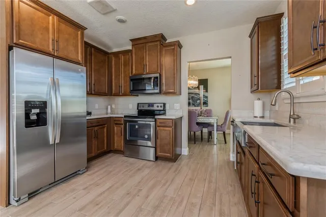 a kitchen with stainless steel appliances granite countertop a refrigerator a stove top oven a sink and dishwasher