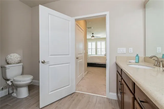 a en suite bathroom with a granite countertop toilet sink and mirror
