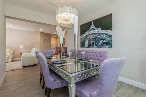 a dining room with furniture a chandelier and wooden floor